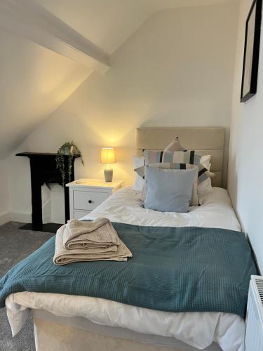 a bedroom with a bed with a green blanket on it at Heathcliff - 5 Bedroom House in Town Centre in Pembrokeshire