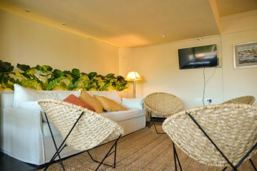 a living room with a white couch and chairs at Hotel De La Barra in Punta del Este