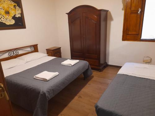 sypialnia z 2 łóżkami i drewnianą szafką w obiekcie Da laura w Trapani