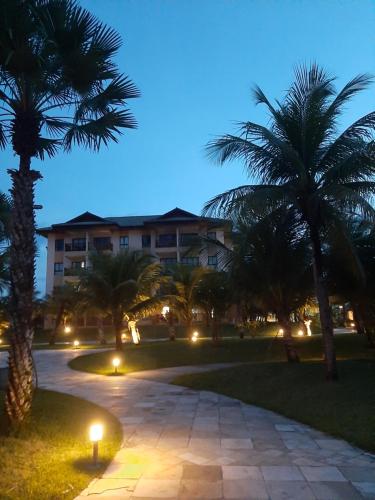 a building with palm trees and a walkway at night at VG SUN CUMBUCO-Lake Flat C1 201 1 a 4 pessoas in Caucaia