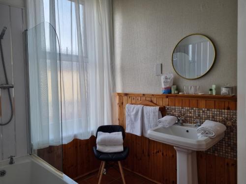 a bathroom with a sink and a tub and a mirror at Sirocco Blues Guest House in Blackpool