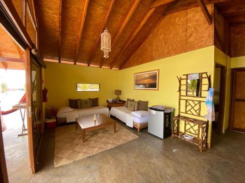 sala de estar con sofá y mesa en Wallac Bungalows Canoas de Punta Sal, en Canoas de Punta Sal