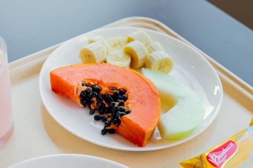 a plate of food with a salmon and fruit on it at HUS HOTEL Dourados in Dourados