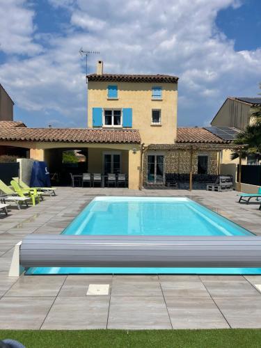 une piscine devant une maison dans l'établissement Maison 8-10 pers avec piscine aux portes de St Aygulf, à Fréjus