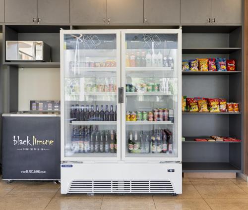 a white refrigerator filled with lots of drinks at HUS HOTEL Dourados in Dourados
