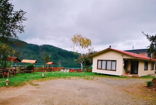 a small house with a dirt road in front of it at Camping & Cabaña Los Arrayanes Niebla in Valdivia