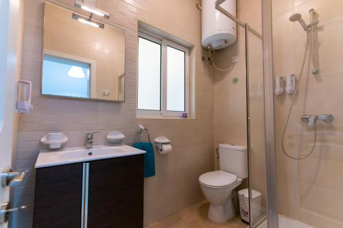 La salle de bains est pourvue de toilettes, d'un lavabo et d'une douche. dans l'établissement Seaside Cosy Maisonette @ Marsaskala - 2 mins walk from sea, à Marsaskala