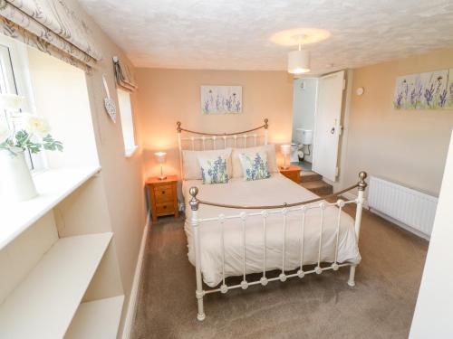 a bedroom with a white bed and a window at Meadows Edge in Holwick