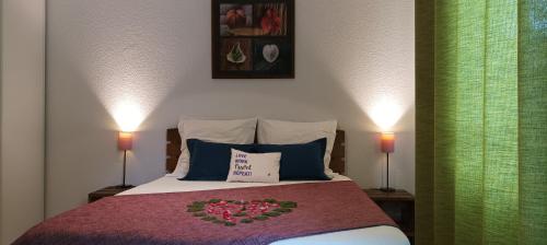 a bedroom with a bed with two lamps and two pillows at Les Terrasses du Lac piscine M65 in Aureilhan