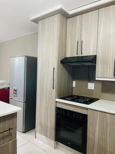 a kitchen with a stove and a refrigerator at Moh Ville Guest House in Maseru