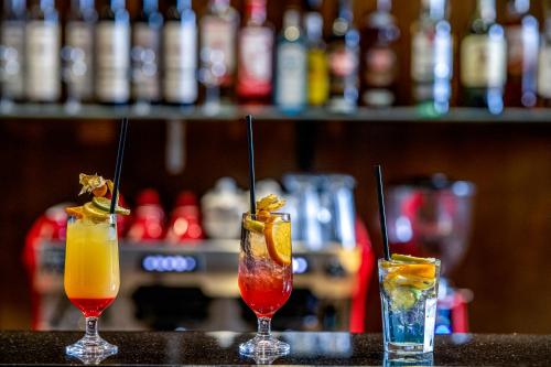 tre cocktail seduti sopra un bar di Willis Hotel Business & Wellness a Zalaegerszeg