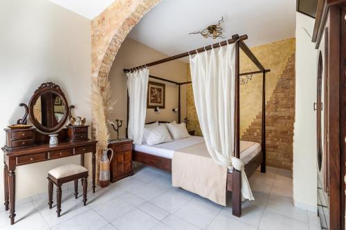 a bedroom with a canopy bed and a mirror at Yianna Cottage Studios in Skopelos Town