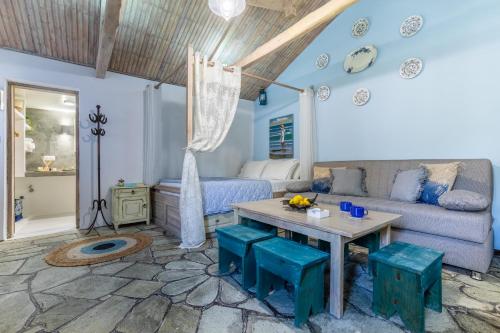 a living room with a couch and a table at Yianna Cottage Studios in Skopelos Town