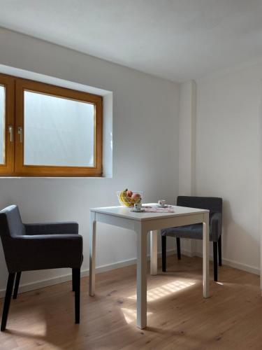 a table and chairs in a room with a window at Schöne Souterrainwohnung in Seeshaupt in Seeshaupt