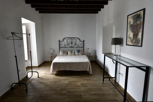 una camera da letto con un letto in una stanza bianca di La Fuente Apartamento Jerez a Jerez de la Frontera