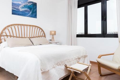 1 dormitorio con 1 cama, 1 silla y 1 ventana en Villa Sofía Fuerteventura, en Lajares