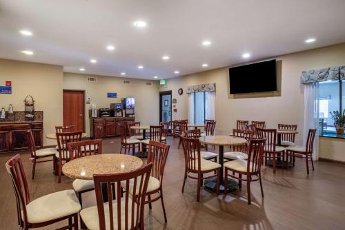 un ristorante con tavoli e sedie e una TV a schermo piatto di Best Western Troy Inn a Troy