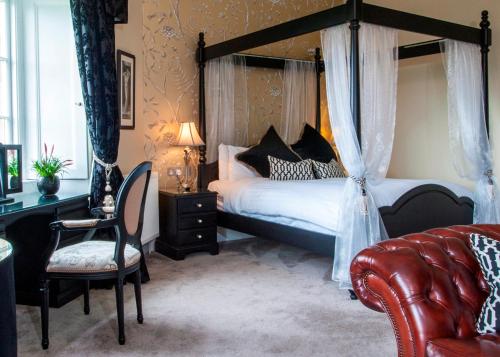 a bedroom with a canopy bed and a chair at Coul House Hotel in Contin