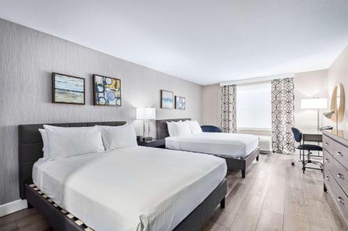 a hotel room with two beds and a desk at Fountain Park Hotel BW Signature Collection in Fountain Hills