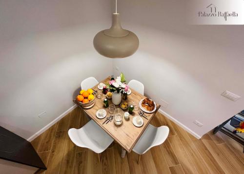 - une table à manger avec des fleurs et des fruits dans l'établissement Appartamento Palazzo Raffaella, à Castel SantʼElia