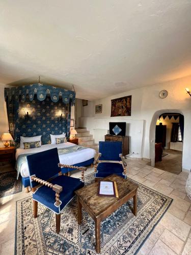 a bedroom with a king sized bed and blue chairs at Château de Trigance in Trigance