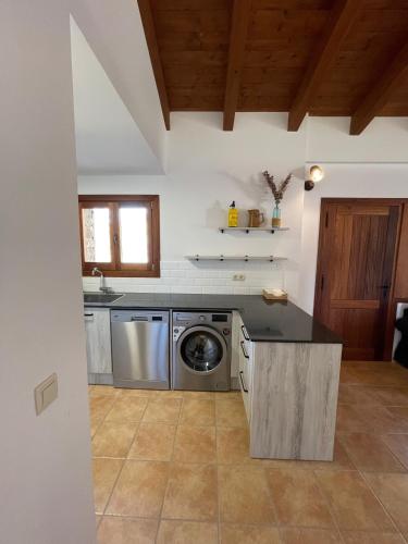 a kitchen with a washer and a washing machine at Apartaments Cal Borda in Coll de Nargó