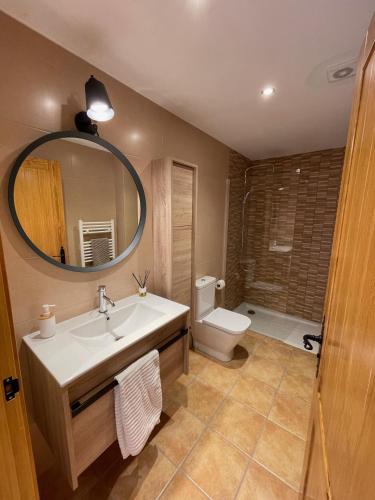 a bathroom with a sink and a toilet and a mirror at Apartaments Cal Borda in Coll de Nargó