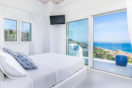 1 dormitorio con cama y ventana grande en Villa Mariel Skopelos, en Skopelos Town