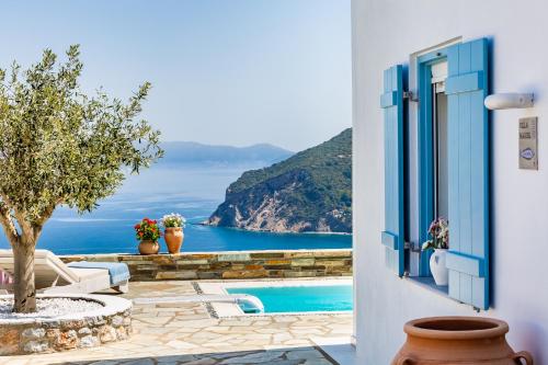 a door to a balcony with a view of the ocean at Villa Mariel Skopelos in Skopelos Town