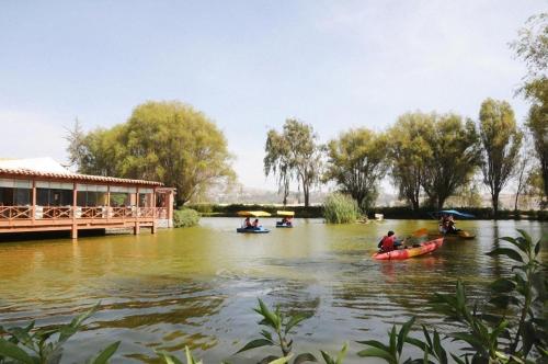 people are paddling in a canoe on a river at BTH Hotel Arequipa Lake in Arequipa