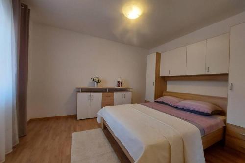 1 dormitorio con 1 cama grande y cocina en Vrlika, Peruća Lake Holiday House, en Vrlika