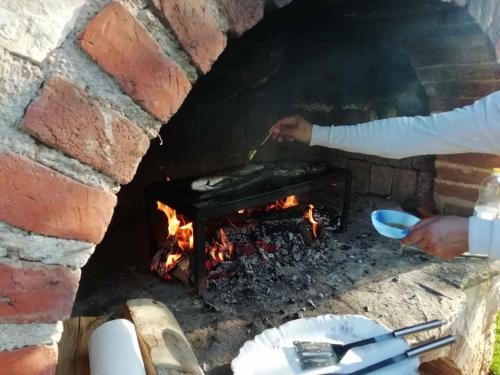 een persoon die eten kookt in een bakstenen oven bij Apartments in Porec - Istrien 42541 in Poreč