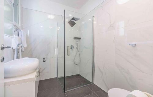 uma casa de banho branca com um chuveiro e um lavatório. em Apartments in Porec - Istrien 42535 em Porec