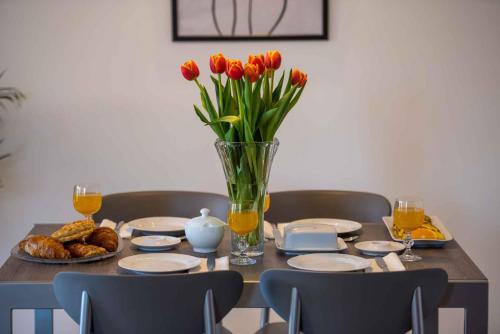 a table with a vase of red tulips and a vase of orange at Apartment in Malinska Insel Krk 13004 in Malinska