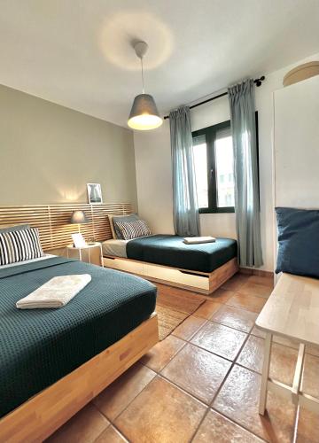 a bedroom with two beds and a window at Seafront Maisonette in Pefkochori