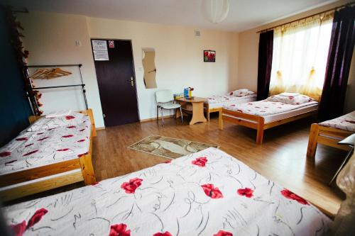 a room with two beds with red flowers on them at Tanie Noclegi 2 in Kielce