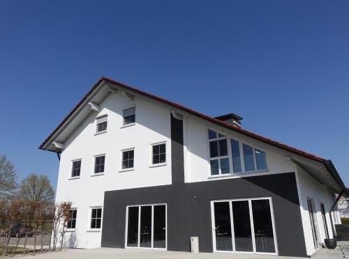a white house with black trim and windows at Das SinGold Hotel mit Highspeed WLAN und digitalem Schlüssel in Schwabmünchen