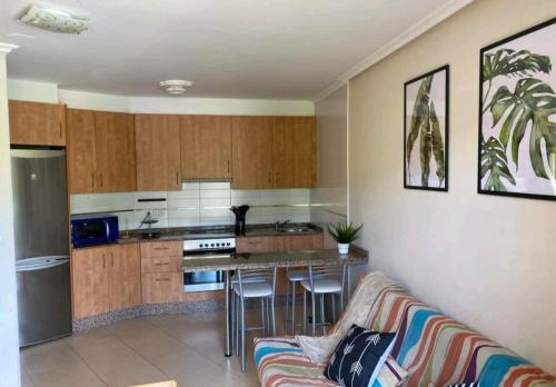 sala de estar con sofá y cocina en Ático con piscina, en Porto de Espasante