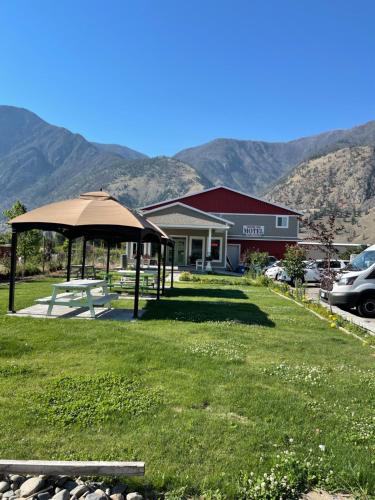 un cenador en un patio frente a un edificio en Orchard View Motel, en Keremeos