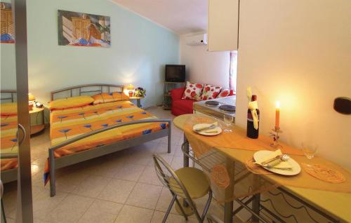 a bedroom with a bed and a table and a kitchen at Lovely Apartment In Pula With Kitchen in Pula