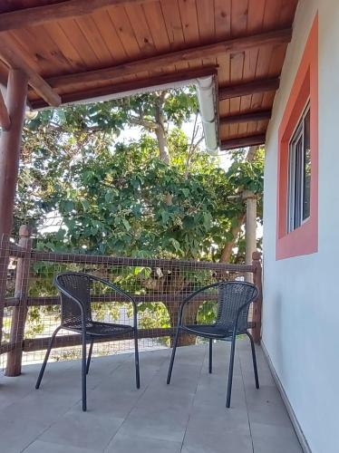 un patio con 2 sillas y una mesa en Cabaña Céntrica con Balcón Vista a las Sierras en Cosquín