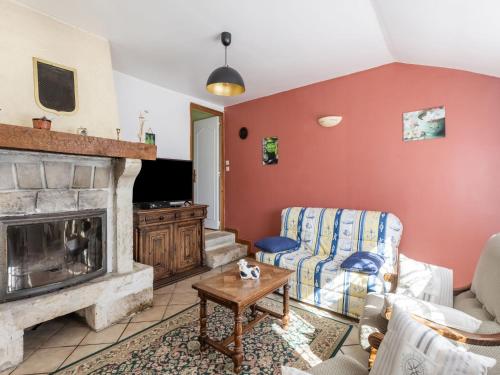 a living room with a fireplace and a couch at Beautiful holiday home with garden in Tamerville