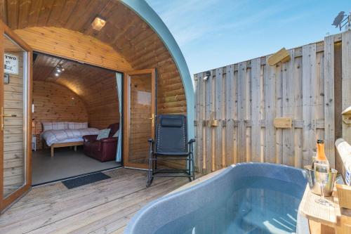 a bathroom with a tub in a room with a bedroom at Two Hoots in Flint