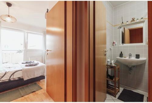 Un baño con una cama y un lavabo en una habitación. en Die kleine „Louise“ in der Neustadt mit Tiefgarage, en Dresden