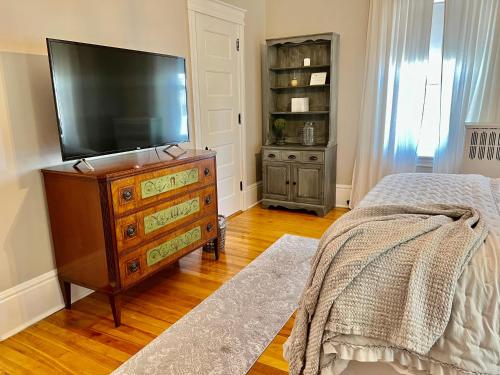 a bedroom with a flat screen tv and a dresser at Vida Boutique Inn in Worcester