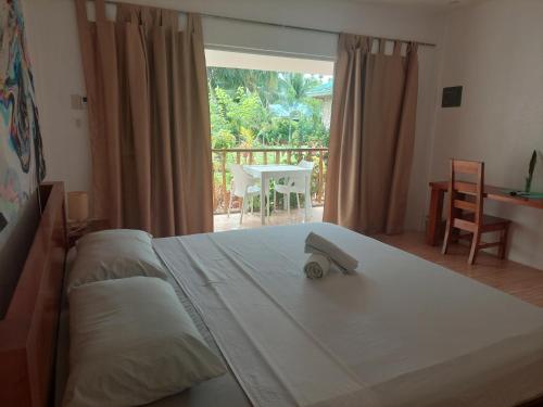 1 dormitorio con 1 cama y ventana con mesa en Becano Restobar and Resort, en Siquijor