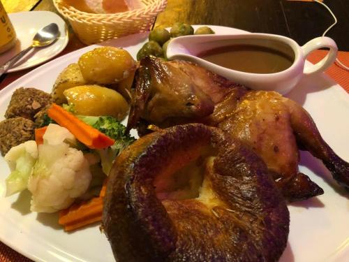 a plate of food with meat and vegetables on a table at Hideaway Guest House And Bar in Pattaya Central