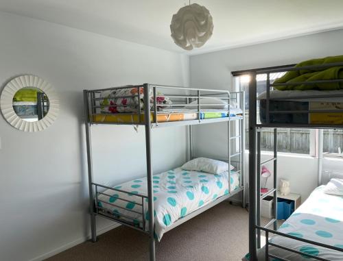 מיטה או מיטות קומותיים בחדר ב-Surfers Retreat - Waihi Holiday Home
