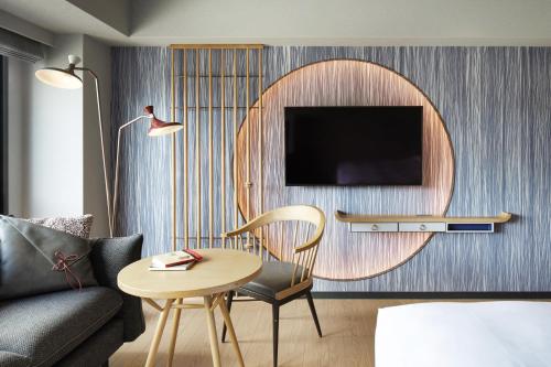 a living room with a couch and a table and a mirror at Mercure Kyoto Station in Kyoto