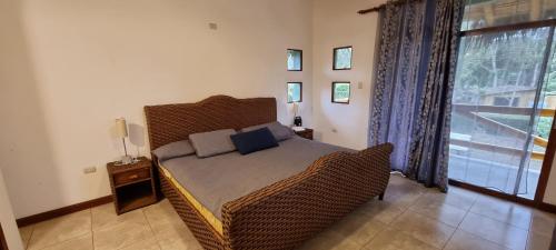 een slaapkamer met een bed en een groot raam bij Casa vacacional campestre cerca de la playa in Santa Elena